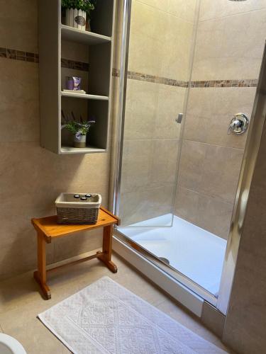 a bathroom with a shower with a wooden table at Casa panoramica Villasimius in Villasimius