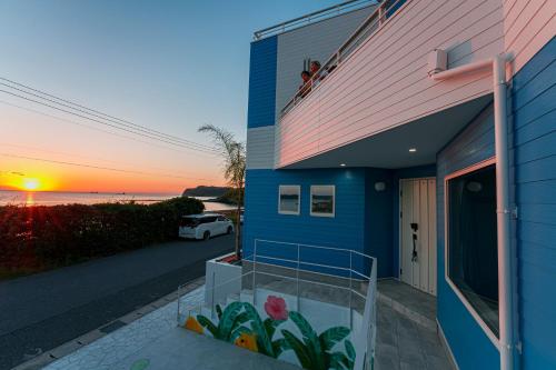 une maison dotée d'un balcon avec vue sur le coucher de soleil en arrière-plan. dans l'établissement HOMIE TERRACE Funakata, à Tateyama