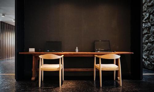 a table with two chairs and two computers on it at Calafate Parque Hotel in El Calafate