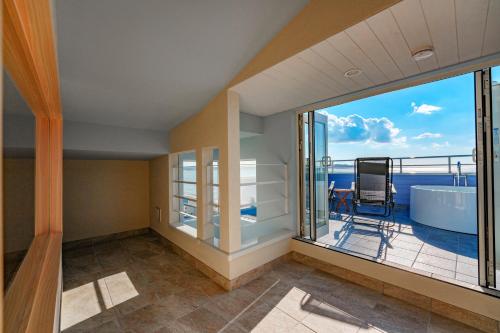 a balcony with a tub and a view of the ocean at HOMIE TERRACE Funakata in Tateyama