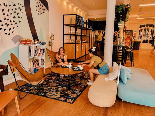 two women sitting at a table in a living room at Viajero Montevideo Hostel in Montevideo