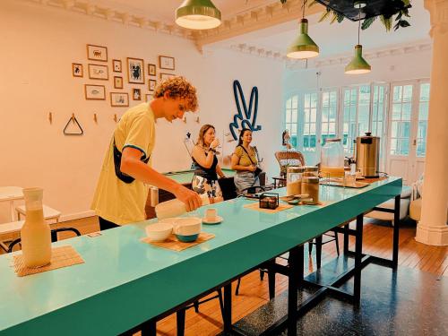 a group of people standing around a table preparing food at Viajero Montevideo Hostel in Montevideo