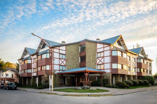 a large apartment building with a blue roof at Calafate Parque Hotel in El Calafate