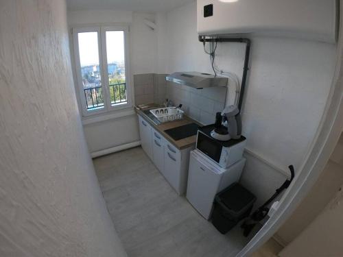 uma pequena cozinha com um lavatório e uma janela em 40m² totalement rénovés belle vue dégagée (001) em Villeneuve-Saint-Georges