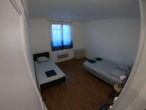 um pequeno quarto com 2 camas e uma janela em 40m² totalement rénovés belle vue dégagée (001) em Villeneuve-Saint-Georges