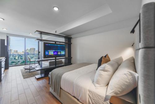 - une chambre avec un grand lit et une télévision à écran plat dans l'établissement Breathtaking Studio with Bay & City Views, à Miami