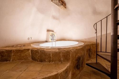 a bathroom with a stone tub in a room at Case degli Avi 2, antico abitare in grotta in Modica