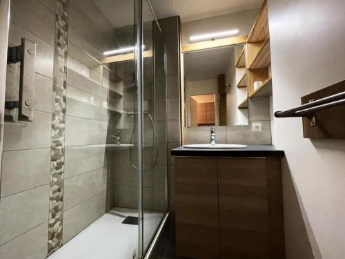 ein Bad mit einer Dusche und einem Waschbecken in der Unterkunft Résidence Lac Du Lou - Studio pour 4 Personnes 214 in Les Menuires