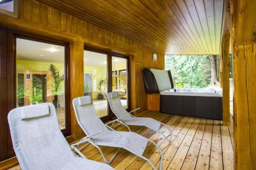 a room with three chairs and a bath tub at Hotýlek pod smrkem in Harrachov