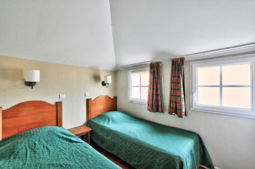 um quarto com 2 camas e uma janela em La résidence du Lac - maeva Home - Maison 3 Pièces 6 Personnes - Confort 764 em Monflanquin