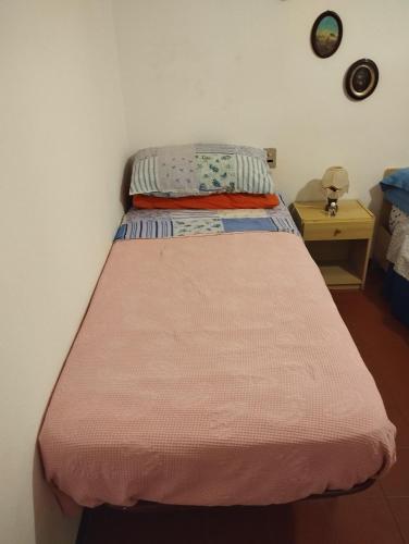 a bedroom with a bed with a pink blanket at Casa Ricciola in Principina a Mare