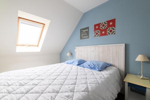 - une chambre avec un grand lit aux murs bleus et une fenêtre dans l'établissement Port du Crouesty Cap'Océan - maeva Home - Appartement 3 pièces 7 personnes - Sélection - vue sur le Port MAE-5824, à Arzon