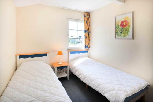 deux lits dans une petite pièce avec une fenêtre dans l'établissement Résidence Port Bourgenay - maeva Home - Maison 3 pièces 6 personnes - Confort MAE-7304, à Talmont-Saint-Hilaire