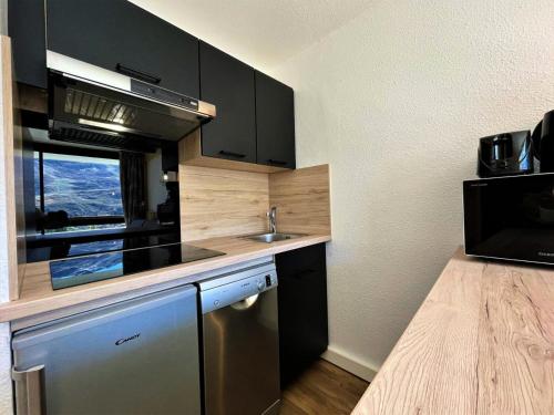 - une cuisine avec des placards noirs et un évier dans l'établissement Résidence Tougnette - Chaleureux appartement 4 pers - idéal famille - pied de pistes MAE-5314, aux Menuires