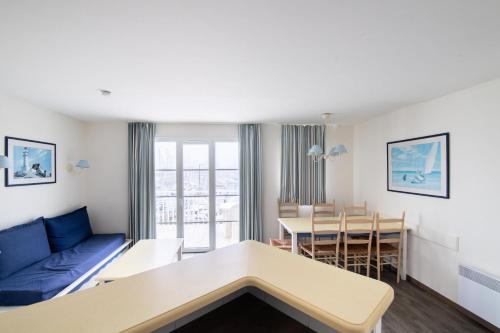 - un salon et une salle à manger avec un canapé bleu dans l'établissement Port du Crouesty Cap'Océan - maeva Home - Appartement 3 pièces 6 personnes - Sélection - vue sur le Port MAE-8934, à Arzon