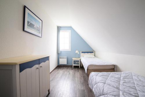 une chambre avec deux lits et un bureau et une fenêtre dans l'établissement Port du Crouesty Cap'Océan - maeva Home - Appartement 4 pièces 9 personnes - Confort - vue sur le Port MAE-8944, à Arzon