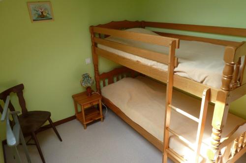 1 Schlafzimmer mit 2 Etagenbetten und einem Stuhl in der Unterkunft Au Petit Petonfaing in Le Syndicat