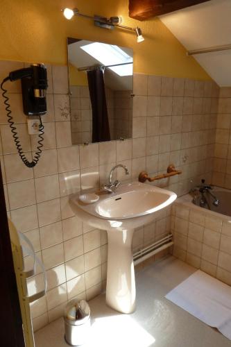 La salle de bains est pourvue d'un lavabo et d'un téléphone mural. dans l'établissement Au Petit Petonfaing, à Le Syndicat