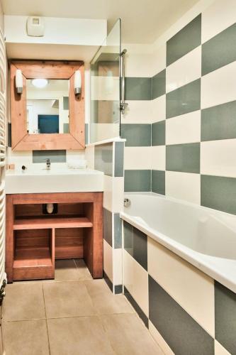 une salle de bain avec une baignoire, un lavabo et un miroir dans l'établissement Résidence Belle Dune - maeva Home - Appartement 2 pièces 4 personnes - Sélection MAE-9334, à Fort-Mahon-Plage