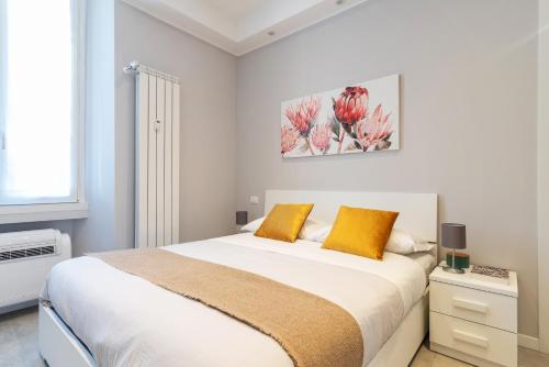 sypialnia z dużym białym łóżkiem z pomarańczowymi poduszkami w obiekcie Filippi Flexyrent apartment A.C. w Mediolanie