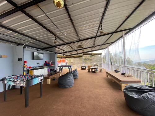 Großes Zimmer mit einem Balkon mit einem Tisch und Bänken. in der Unterkunft The Rare Ones - Resorts, Cafe & Game Zone in Mukteswar