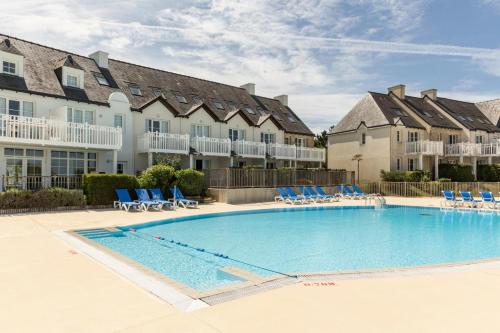 una piscina en un complejo con sillas y apartamentos en condominio en Port du Crouesty Cap'Océan - maeva Home - Appartement 2 Pièces 4 Personnes 424, en Arzon