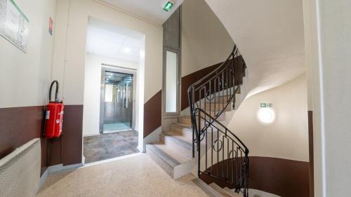 a hallway with a spiral staircase in a house at Hôtel Des Docks in Digoin