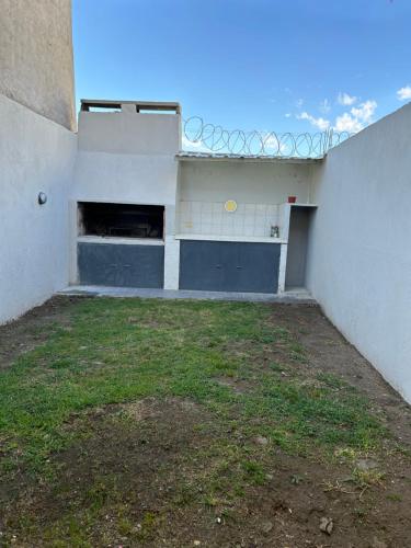 een leeg gebouw met een tennisbaan in een tuin bij Duplex 2 Dormitorios Neuquén in Neuquén