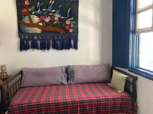 a couch sitting in a room with a plaid blanket at Sítio paiol Velho in Cristina