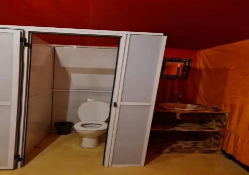 ein Badezimmer mit Toilette und Duschkabine in der Unterkunft Desert Season Camp in Merzouga