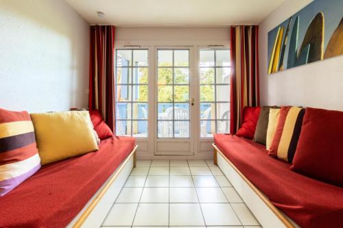 - un salon avec deux canapés rouges et une fenêtre dans l'établissement Village Moliets - maeva Home - Appartement 2 pièces 4 personnes - Confort MAE-9764, à Moliets-et-Maa