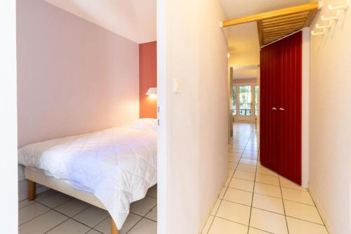 - une chambre avec un lit et une porte rouge dans l'établissement Village Moliets - maeva Home - Appartement 2 Pièces 5 Personnes - Confort MAE-4444, à Moliets-et-Maa