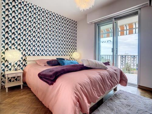 une chambre avec un lit et une grande fenêtre dans l'établissement Appartement vue mer Juan les Pins, à Antibes