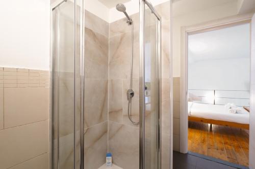 La salle de bains est pourvue d'une douche avec une porte en verre. dans l'établissement PrimoPiano - Acerenza Flats, à Milan