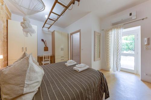 una camera da letto con un letto e due asciugamani di Il Pumo Bianco a Morciano di Leuca