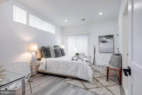 a white bedroom with a bed and a table and chairs at BrandNew Luxury Capitol Hill APT! Near Free Trolly in Washington, D.C.