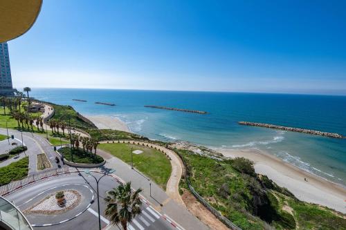 a view of the beach and ocean from a building at פנטהאוז שמיים - דירות יוקרתיות על הים עם ממד,גקוזי פרטי, בריכה ונוף פנורמי לאוקיינוס in Netanya