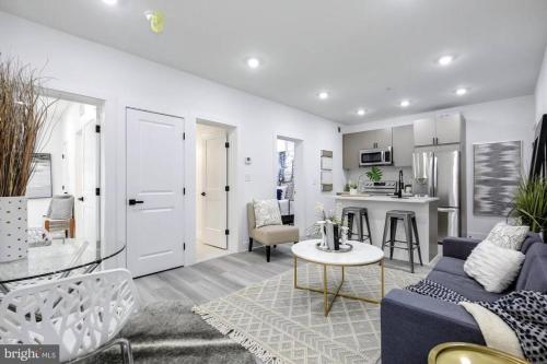 a living room with a couch and a table and a kitchen at BrandNew Luxury Capitol Hill APT! Near Free Trolly in Washington, D.C.