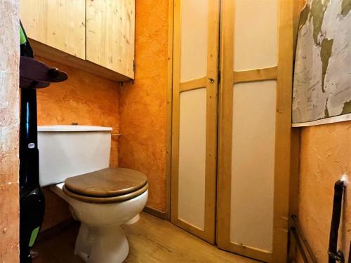 a small bathroom with a toilet with a wooden seat at Résidence Peclet - 2 Pièces pour 4 Personnes 454 in Les Menuires