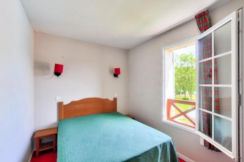 une petite chambre avec un lit et une fenêtre dans l'établissement La résidence du Lac - maeva Home - Maison 3 Pièces 6 Personnes - Sélection MAE-5414, à Monflanquin