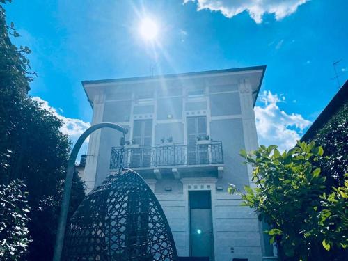 a house with a balcony and the sun in the sky at Villa Martina Retreat in Lecco