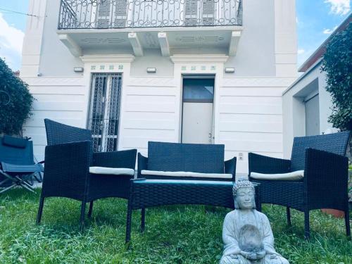 Une statue assise dans l'herbe devant une maison dans l'établissement Villa Martina Retreat, à Lecco