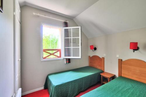 une chambre avec deux lits et une fenêtre dans l'établissement La résidence du Lac - maeva Home - Maison 3 pièces 6 personnes - Sélection MAE-5434, à Monflanquin