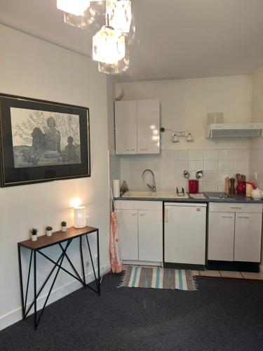 une cuisine avec des armoires blanches et une table dans l'établissement Studio Paris Bastille, à Paris