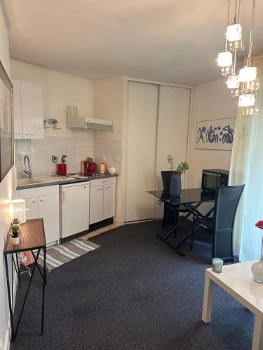 une cuisine et une salle à manger avec une table et des chaises dans l'établissement Studio Paris Bastille, à Paris