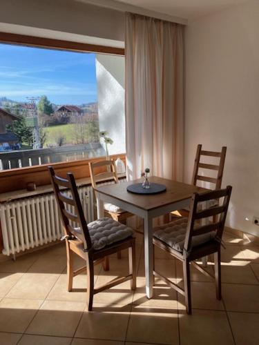 a table and chairs in a room with a window at Ferienwohnung Aigisblick mit Pool und Sauna, direkt am Skihang in Missen-Wilhams