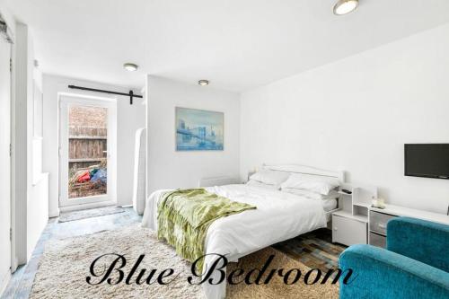 ein weißes Schlafzimmer mit einem Bett und einem blauen Stuhl in der Unterkunft Exmoor Close in North Hykeham
