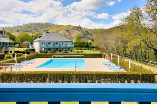 - une piscine en face d'une grande maison dans l'établissement Résidence Les Belles Rives - maeva Home - Appartement 2 Pièces 5 Personnes - Sélection MAE-2194, à Argentat