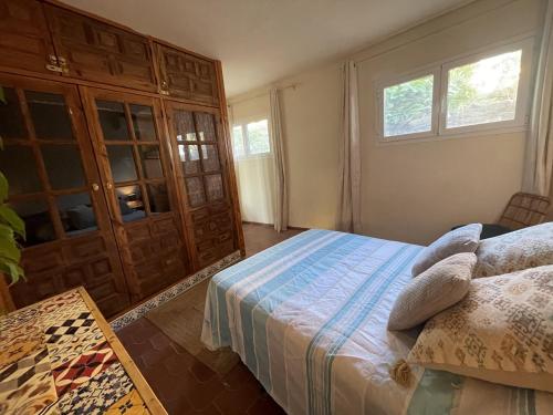 a bedroom with a bed and a cabinet and two windows at Casa Vista Panorámicas in Mojácar