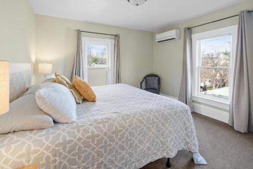 een slaapkamer met een wit bed met kussens en een raam bij Pioneer Vacation Rentals - Pioneer North Suite downtown Ashland in Ashland